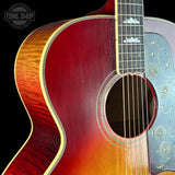 Close-up of a red acoustic guitar with a black background