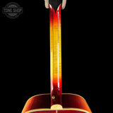 Close-up of a guitar's neck and headstock with a black background, featuring the Tone Shop logo.