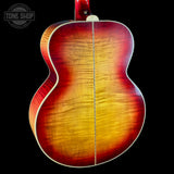 Back view of a sunburst acoustic guitar with 'Tone Shop' logo.