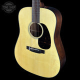 Acoustic guitar with a visible brand logo on a black background