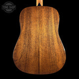 Close-up of a wooden acoustic guitar back with 'Tone Shop' logo.