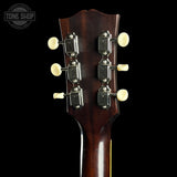 Close-up of a guitar headstock with tuning pegs on a black background, featuring 'Tone Shop' branding.