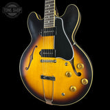 Electric guitar with a sunburst finish on a black background, featuring the Tone Shop logo.