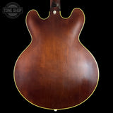 Back view of a brown acoustic guitar with 'Tone Shop' logo in the corner.