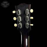 Close-up of a guitar headstock with tuning pegs on a black background, featuring 'Tone Shop' branding.