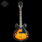 Electric guitar with a sunburst finish on a black background, featuring the Gibson logo.