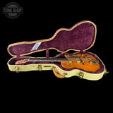 Gibson guitar in a purple case with 'Tone Shop' logo.