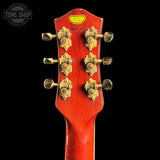 Close-up of a red guitar headstock with tuning pegs on a black background, featuring 'Tone Shop' branding.
