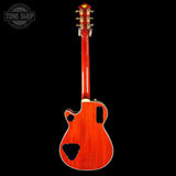 Back view of a red electric guitar with a black background