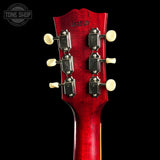 Close-up of a red guitar headstock with tuning pegs on a black background, featuring 'Tone Shop' logo.