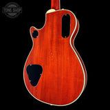 Back view of a red electric guitar with a visible brand logo in the corner.