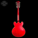 Red electric guitar on a black background with 'Tone Shop' logo.