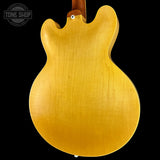 Back view of a guitar with a visible brand logo in the corner.