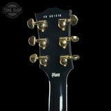 Gibson guitar headstock with tuning pegs on a black background