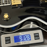Guitar on a digital scale displaying weight