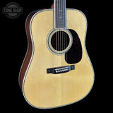 Acoustic guitar with a visible brand logo on a black background