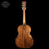 Back view of a wooden acoustic guitar with 'Tone Shop' logo in the corner.