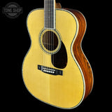Acoustic guitar with a visible brand logo on a black background