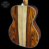 Close-up of a wooden acoustic guitar with a dark and light wood pattern on a black background.