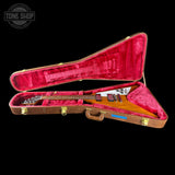 Guitar in a red-lined case with 'Tone Shop' logo in the corner.