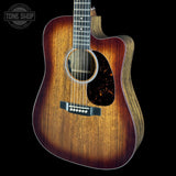 A cutaway acoustic guitar with a natural wood body and a dark brown sunburst finish, shown against a solid black background. A Tone Shop watermark is visible in the top-left corner.