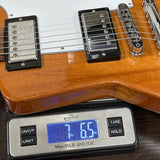 Guitar being weighed on a digital scale with a wooden finish.
