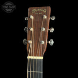 Close-up of a Martin & Co guitar headstock with brand logo on a black background