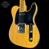 A yellow-finished electric guitar with a black pickguard and chrome hardware, photographed against a black background. A Tone Shop watermark is visible in the top-left corner.