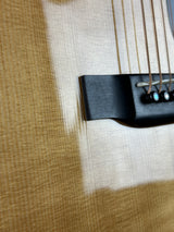 Close-up of a guitar's soundhole and bridge on a wooden surface