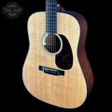 Acoustic guitar with a visible brand logo on a black background