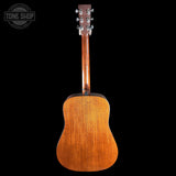 Back view of a wooden acoustic guitar on a black background with 'Tone Shop' logo.