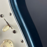 Close-up of a guitar's control knobs and body on a dark background