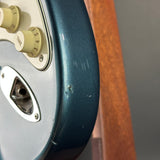 Close-up of a guitar with control knobs and a wooden neck.