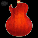 Back view of a red electric guitar with a visible brand logo in the corner.
