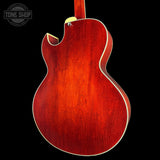 Red electric guitar body on a black background with 'Tone Shop' logo.
