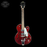 Red electric guitar with a white pickguard on a black background, featuring the Gretsch logo.