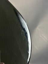 Close-up of a black surface with visible scratches and a logo.