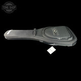 A black guitar headstock hard case with a zippered pocket and a hanging white tag, shown against a solid black background. A Tone Shop watermark is visible in the top-left corner.