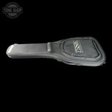 A black guitar gig bag with a silver-toned metal logo plate on the front pocket, shown against a solid black background. A Tone Shop watermark is visible in the top-left corner.