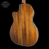 Wooden acoustic guitar body with 'Tone Shop' logo in the corner.