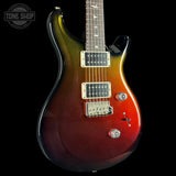 A classic electric guitar with a dark brown to black gradient finish on the lower half and a warm amber/orange to gold gradient on the upper half, shown against a solid black background.