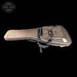 Brown guitar case with 'SE' branding on a black background, featuring the Tone Shop logo.