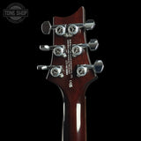 Guitar headstock with tuning pegs on a black background, featuring the Tone Shop logo.