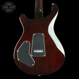 Guitar body with a dark finish and visible brand logo on a black background