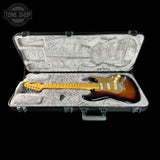 Electric guitar in a hard-shell case with 'Tone Shop' logo.