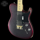 A close-up of a Fender electric guitar body in a dark metallic purple sparkle finish, featuring a black pickguard, gold hardware, and a light maple neck, shown against a black background with a Tone Shop watermark.