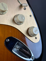 Close-up of a guitar's control knobs and switch on a dark background