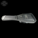 A black guitar case with a padded headstock cover, shown from a side angle against a solid black background. A Tone Shop watermark is visible in the top-left corner.