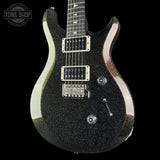 A black electric guitar with a dense silver glitter finish, featuring chrome hardware and a dark fretboard, shown against a solid black background with a Tone Shop watermark in the top-left corner.