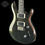 A black glitter electric guitar with a glossy finish, featuring silver hardware and a dark fretboard, shown against a solid black background with a Tone Shop watermark in the top-left corner.